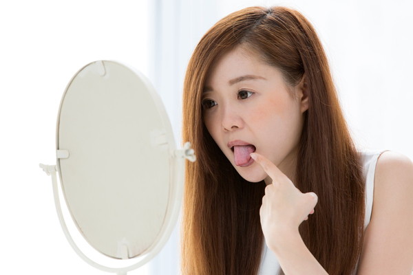 鏡で舌を見る女性